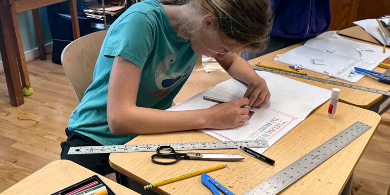 Middle school student working on school work with pencil, scissors, and t-square
