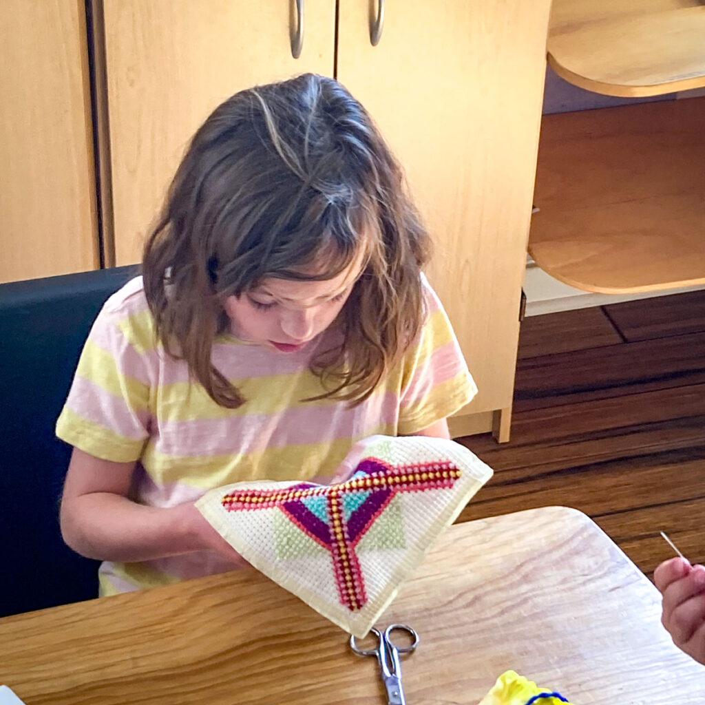 student working on cross stitch