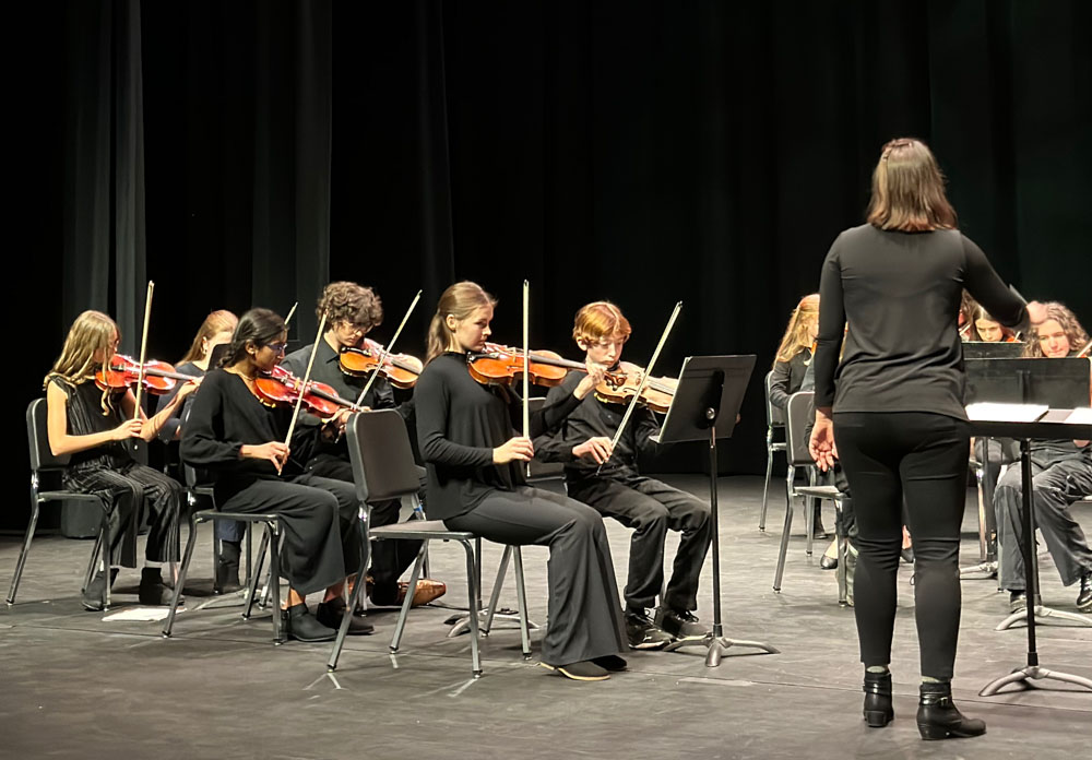 middle school orchestra students performing on stage