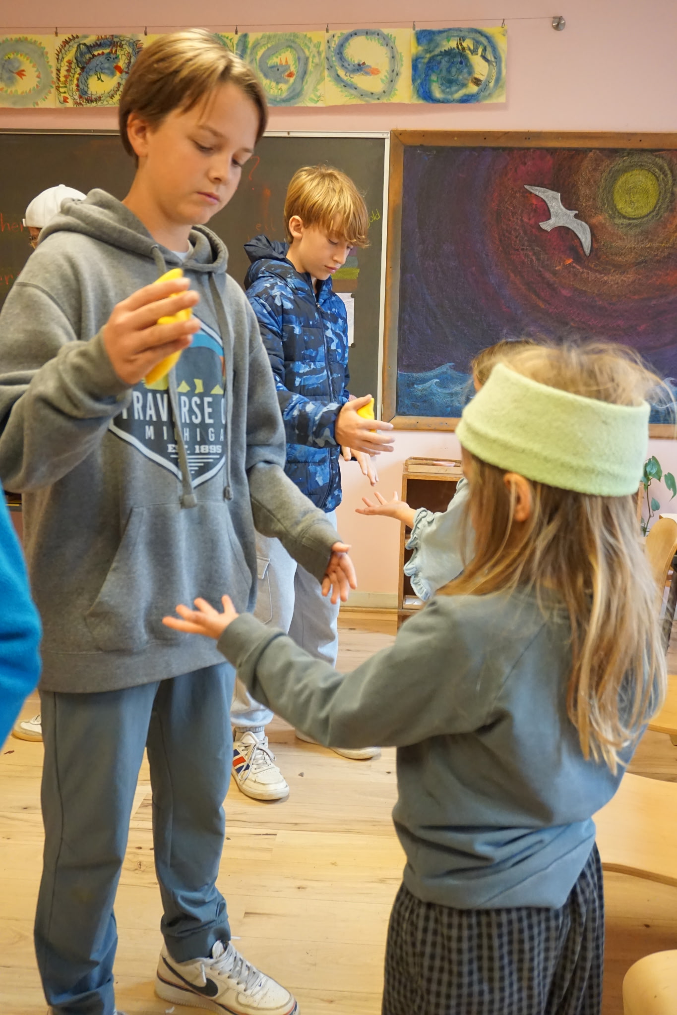 older and younger Waldorf students sharing beanbag game