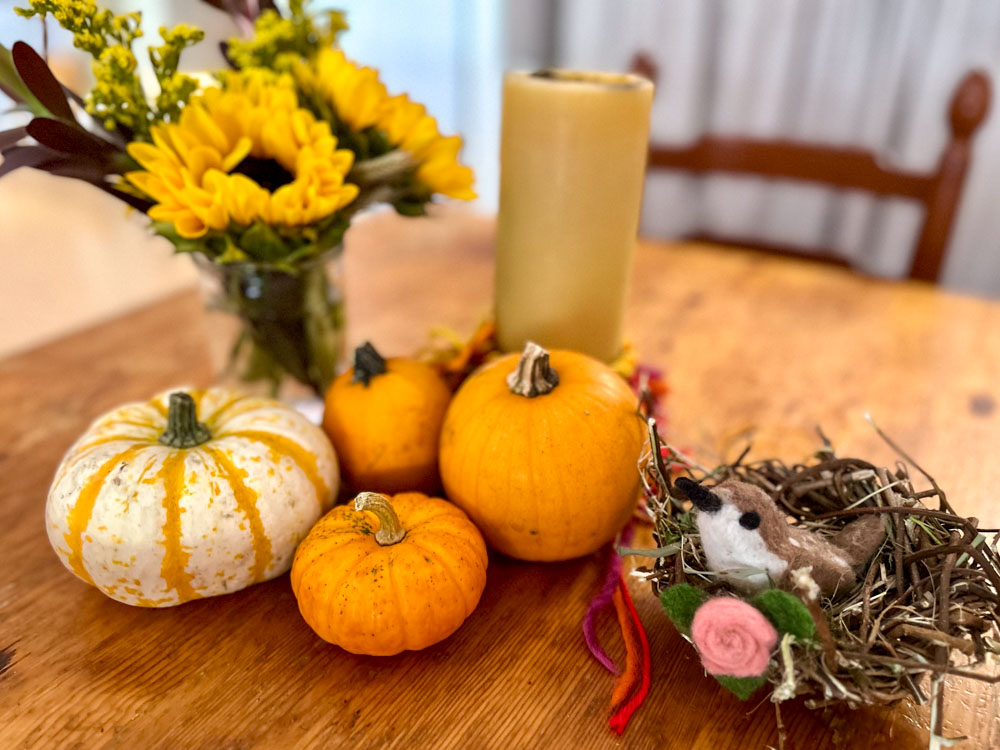 early childhood table set for fall with pumpkins and little birds nest