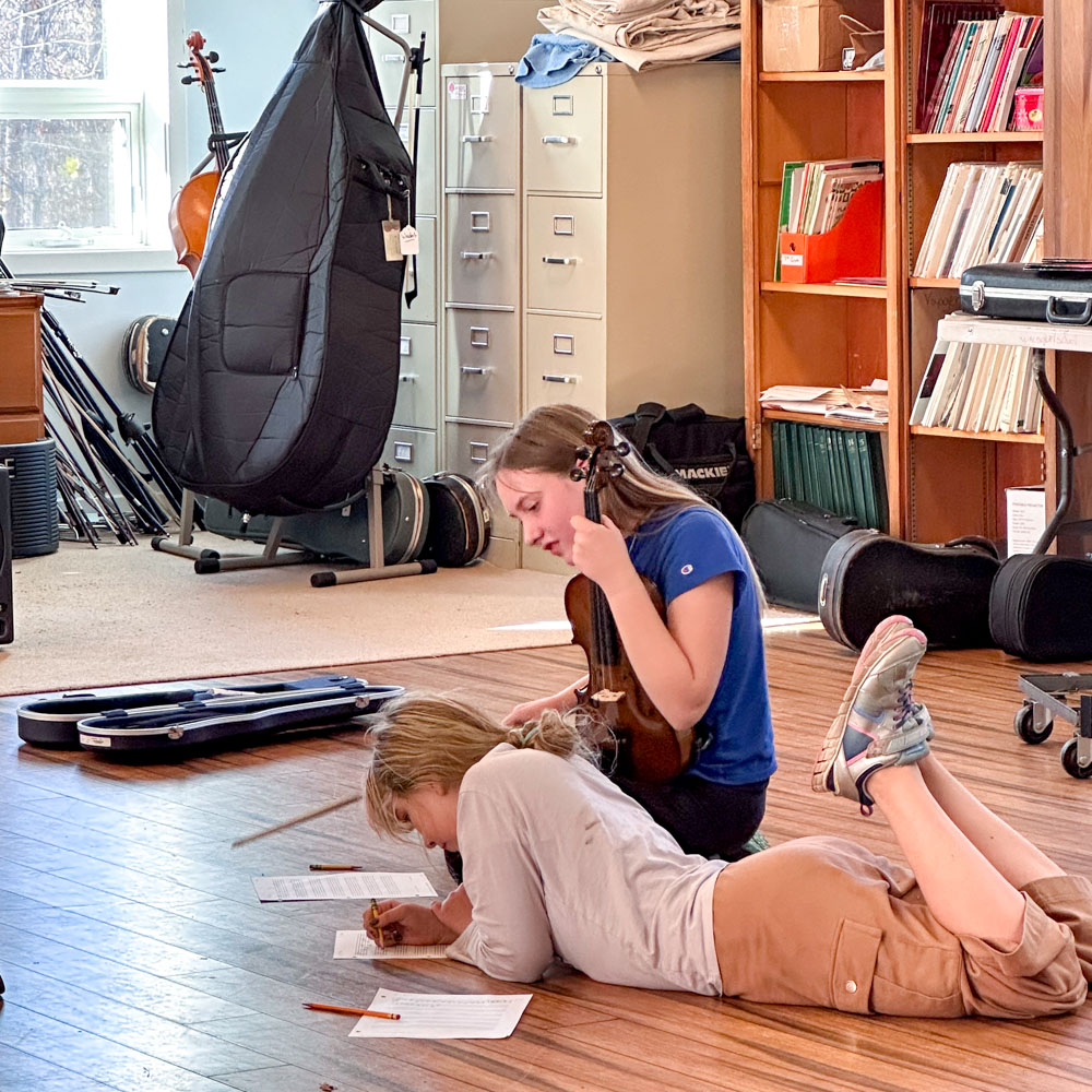 students writing music in orchestra class