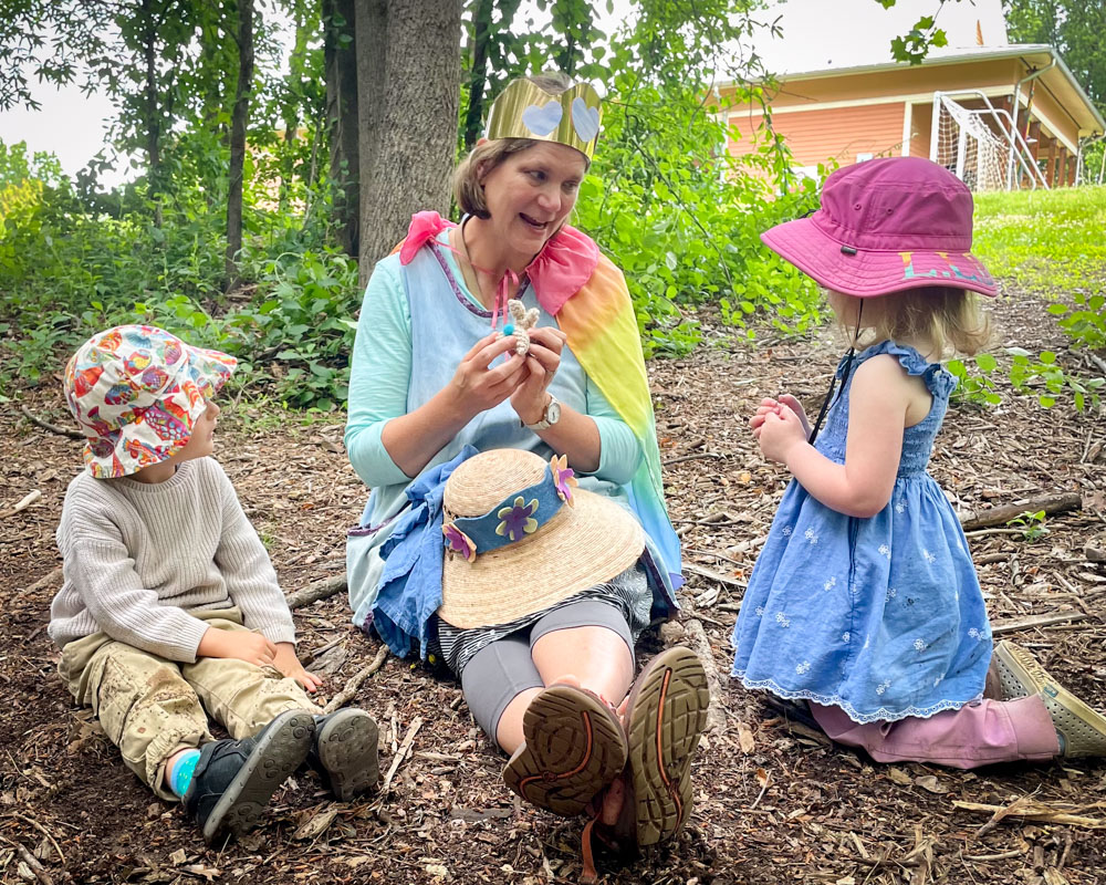 earlly childhood students and teacher celebrating in the forest