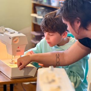 cws middle school student learning to sew on a sewing machine